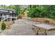 Wide backyard view features a gravel lot, rear home elevation, a wooden fence, and greenery at 3270 Brookview Dr, Marietta, GA 30068