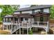 The home's backyard features a multi-tiered deck, a covered patio, and lush greenery at 3270 Brookview Dr, Marietta, GA 30068