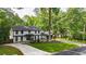 Expansive front yard with mature trees and lush greenery complementing the charming two-story home and long driveway at 3270 Brookview Dr, Marietta, GA 30068