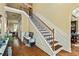 Elegant staircase with dark wood and wrought iron railings, complemented by wainscoting and hardwood floors at 532 Pelham Pl, Mcdonough, GA 30253