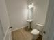 Powder room featuring a pedestal sink, mirror and a toilet at 5383 Heron Bay Blvd, Locust Grove, GA 30248