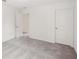 View of a bedroom with neutral walls and light gray carpet, featuring an open doorway and a closed closet door at 5383 Heron Bay Blvd, Locust Grove, GA 30248