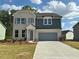 Charming two-story home with a combination brick and siding exterior, attached garage, and inviting curb appeal at 5383 Heron Bay Blvd, Locust Grove, GA 30248