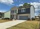 Charming two-story home with a combination brick and siding exterior, attached garage, and long driveway at 5383 Heron Bay Blvd, Locust Grove, GA 30248