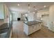 Open concept kitchen featuring a large island, modern cabinets, and laminate flooring at 5383 Heron Bay Blvd, Locust Grove, GA 30248