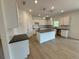 Modern kitchen featuring an island, white cabinets, and laminate flooring at 5383 Heron Bay Blvd, Locust Grove, GA 30248