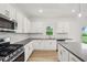 Bright kitchen features white cabinets, stainless appliances and gray countertops at 5383 Heron Bay Blvd, Locust Grove, GA 30248