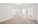 View of a loft with neutral walls and light gray carpet, featuring an open doorway at 5383 Heron Bay Blvd, Locust Grove, GA 30248