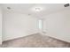 View of a loft with neutral walls and light gray carpet, featuring an open doorway at 5383 Heron Bay Blvd, Locust Grove, GA 30248