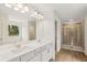 Bright bathroom featuring dual sink vanity, stand alone tub, and glass shower at 5383 Heron Bay Blvd, Locust Grove, GA 30248