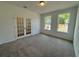 Spacious carpeted office area featuring double doors and plenty of natural light from the windows at 5383 Heron Bay Blvd, Locust Grove, GA 30248