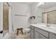 Neutral toned bathroom with a tub-shower combo, minimalist shelving, and classic fixtures at 613 Harrington Hls, Decatur, GA 30032
