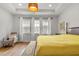 Bright bedroom with a tray ceiling, hardwood floors, and a rocking chair by the window at 613 Harrington Hls, Decatur, GA 30032