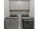 Efficient laundry room featuring modern, stainless steel front-loading washer and dryer at 613 Harrington Hls, Decatur, GA 30032
