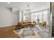 Open-concept living room boasts hardwood floors, modern furniture, a large window and eye-catching chandelier at 613 Harrington Hls, Decatur, GA 30032