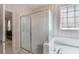 Bathroom with glass shower and large soaking tub featuring decorative window at 6355 Marlow Dr, Cumming, GA 30041