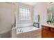 Bright bathroom featuring a soaking tub with decorative window, and glass shower enclosure at 6355 Marlow Dr, Cumming, GA 30041