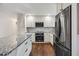 Well-lit kitchen featuring white cabinets, a stainless-steel refrigerator, and a granite countertop island at 2079 Nancy Se Cir, Smyrna, GA 30080