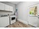 Laundry room features white cabinets, a washer, a dryer, and wood-look flooring at 2079 Nancy Se Cir, Smyrna, GA 30080