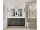 Bathroom with dual sinks, grey cabinets and a glass-enclosed shower with bench at 4065 Holland Grove Rd, Lawrenceville, GA 30044
