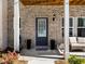 An inviting front door with glass and seating outside creates an welcoming entrance at 4065 Holland Grove Rd, Lawrenceville, GA 30044