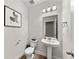 Clean powder room with a pedestal sink, modern fixtures, and neutral decor at 4065 Holland Grove Rd, Lawrenceville, GA 30044
