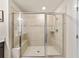 A glass shower enclosure with a bench, tan tiling and decorative accent stripe at 4065 Holland Grove Rd, Lawrenceville, GA 30044