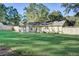 Fenced backyard featuring a large grassy lawn, mature shade trees, and a back door at 715 Cowan Rd, Covington, GA 30016