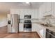 Bright kitchen featuring granite counters, stainless appliances, and wood flooring at 715 Cowan Rd, Covington, GA 30016