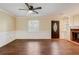 Bright living room with hardwood floors, neutral paint, ceiling fan, and cozy fireplace at 715 Cowan Rd, Covington, GA 30016