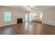 Spacious living room featuring a fireplace, ceiling fan, and wood flooring flowing into the kitchen at 99 Ashtonbrook Dr, Mcdonough, GA 30252