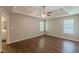 Expansive main bedroom with tray ceilings, ceiling fan, wood-look flooring, and abundant natural light at 99 Ashtonbrook Dr, Mcdonough, GA 30252