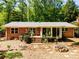 Backyard view of brick home, featuring a patio with deck and a stone fire pit area at 3290 Custer Lake Nw Dr, Marietta, GA 30064