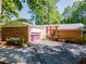 Exterior shot of home with brick facade, lilac garage door, driveway, and landscaping at 3290 Custer Lake Nw Dr, Marietta, GA 30064