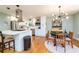 Modern kitchen with stainless steel appliances, white cabinetry, island, and adjacent dining area at 3290 Custer Lake Nw Dr, Marietta, GA 30064