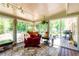 Enclosed sunroom with lots of windows, with a lounge chair, area rug and great outdoor view at 3290 Custer Lake Nw Dr, Marietta, GA 30064