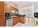 Kitchen with stainless steel dishwasher, double sink, wood cabinets, and black counters at 406 Vinings Forest Se Cir, Smyrna, GA 30080