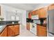 Kitchen with wood cabinets, black counters, appliances, and view into the dining room at 406 Vinings Forest Se Cir, Smyrna, GA 30080