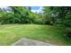A large backyard featuring a large expanse of lawn and lush green trees at 5266 Long Green Ln, Stone Mountain, GA 30088