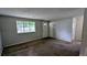Inviting living room with soft carpeting, a large window providing natural light, and neutral wall paint at 5266 Long Green Ln, Stone Mountain, GA 30088