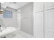 Cozy bathroom with a pedestal sink, tiled shower/tub, and storage shelves at 974 Greenwood Ne Ave # 6, Atlanta, GA 30306