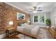 Comfortable bedroom with brick accent wall, natural light, ceiling fan, and neutral decor at 974 Greenwood Ne Ave # 6, Atlanta, GA 30306