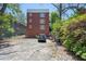 Rear exterior view showcasing a multi-story red brick building, parking area, and landscaping at 974 Greenwood Ne Ave # 6, Atlanta, GA 30306