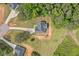 Aerial view of home showcasing large yard, driveway, roof, and surrounding trees at 104 Federal Path, Temple, GA 30179