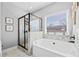 Modern bathroom with a glass-enclosed shower, a luxurious bathtub, and a large window providing natural light at 104 Federal Path, Temple, GA 30179