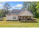 Back exterior view of house with large yard and covered patio with seating at 104 Federal Path, Temple, GA 30179