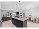 Open-concept kitchen and dining area with a granite island, stainless steel refrigerator, and wooden dining table at 104 Federal Path, Temple, GA 30179
