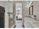 Bathroom with double vanity featuring marble countertops, a glass shower, and access to bedroom at 11189 Serenbe Ln, Chattahoochee Hills, GA 30268