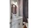 Charming powder room features a white vanity with marble countertop and decorative mirror and stylish lighting at 11189 Serenbe Ln, Chattahoochee Hills, GA 30268