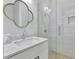 Bathroom with marble vanity, unique mirror, and glass shower, showcasing modern design and fixtures at 11189 Serenbe Ln, Chattahoochee Hills, GA 30268